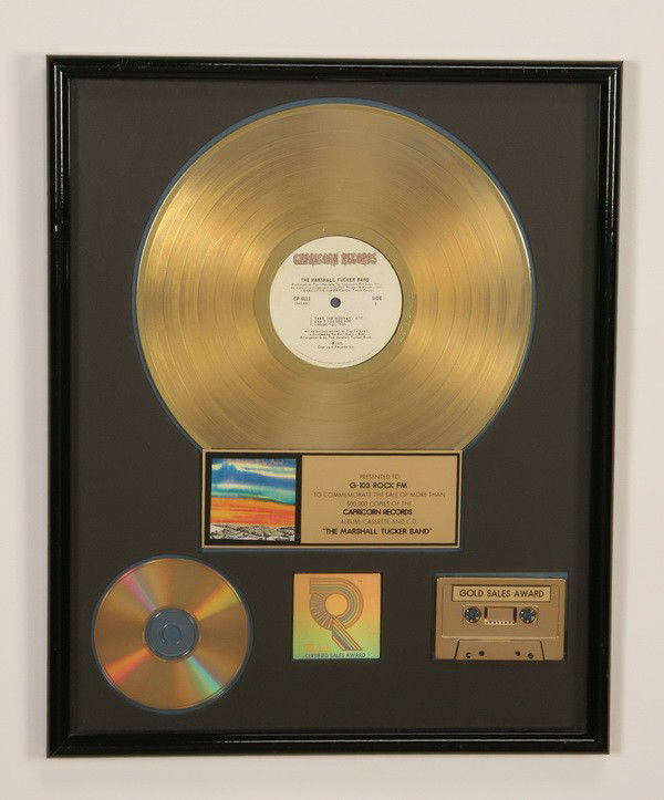 Framed Marshall Tucker Band gold record: Framed commemorative gold record presented to G-103 Rock FM for the sale of more than 500,000 copies of "The Marshall Tucker Band" album, cassette, and CD produced by Capricorn Records, overall size i