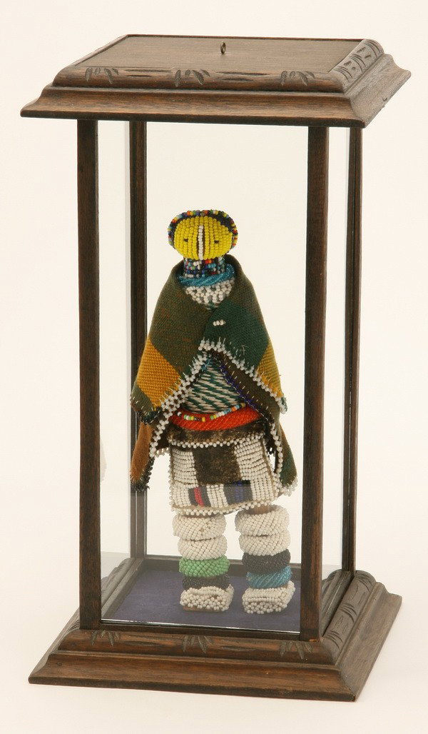 Handcrafted African Ndebele doll: 20th century polychrome beaded African Ndebele doll encased in glass display case, 17"h x 9" square base. Female members of the colorful Ndebele tribe in South Africa create these dolls to promote cul