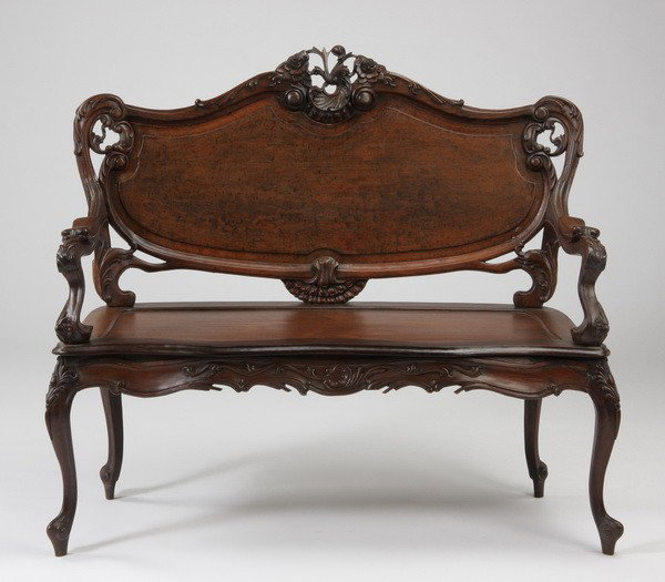 Early 20th c. carved rosewood settee: Early 20th century Louis XV-style carved rosewood settee, the cartouche shaped and paneled back with carved floral crest sweeping to foliate carved arms, raised on cabriole legs, 42"h x 46"w x 17.5"d.