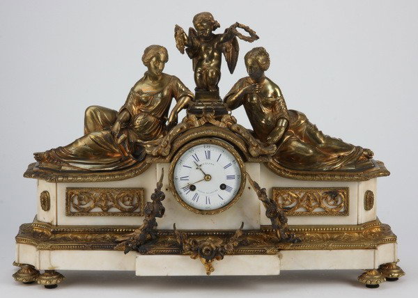 19th c. French bronze and marble clock: Mid 19th century French dore' bronze and white marble figural clock featuring a central putto flanked by reposing maidens depicting the Art of Sculpture and Painting, resting on a bronze mounted marbl
