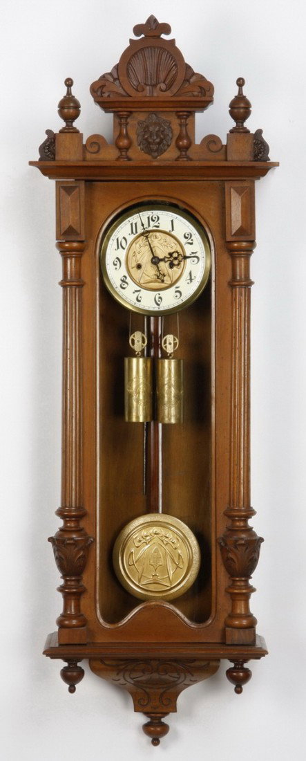 19th c. 2-weight Vienna regulator clock: 19th century carved walnut two weight Vienna regulator clock with stylized shell carved pediment surmounting a lion's mask, the enameled clock face with dore' bronze center and matching pendulum, 47"h