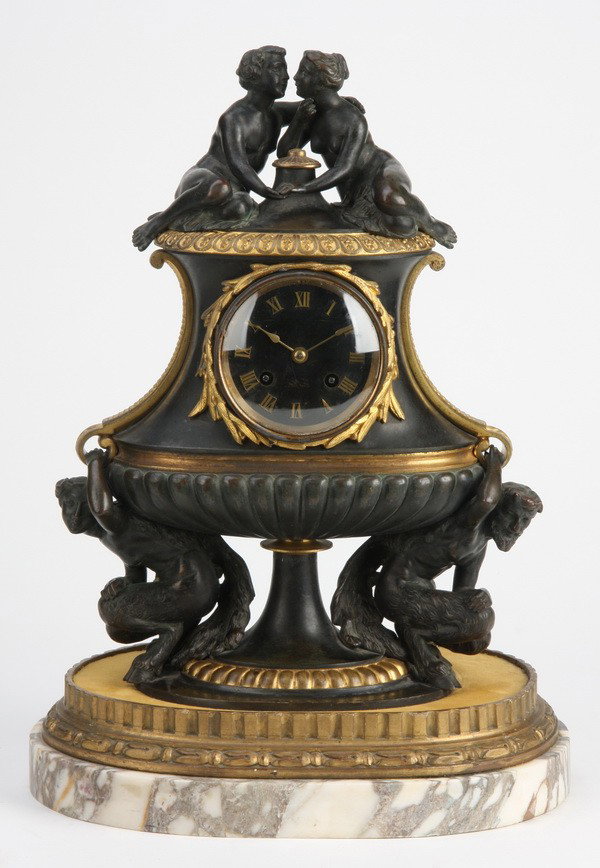 19th c. French bronze figural clock: 19th century French Neoclassical style dore' and patinated bronze figural clock in the form of a lidded urn, the clock face surmounted by a courting couple and supported by two satyrs, all resting on 