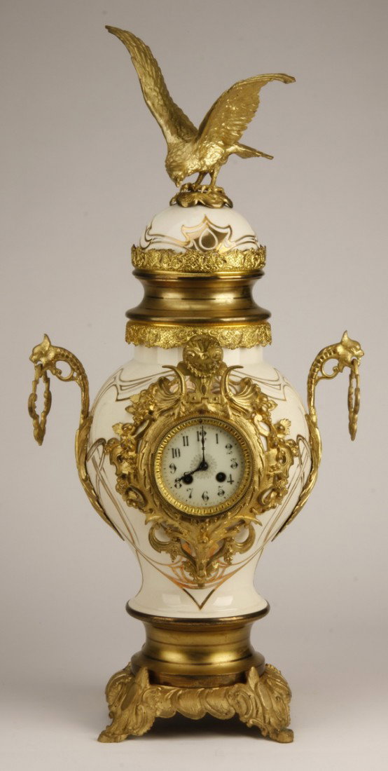 Oversized 19th c. French porcelain clock: Oversized 19th century French Napoleon III dore' bronze mounted clock in the form of a lidded porcelain urn with eagle perched atop, flanked by handles in the form of gryphon masks holding rings, the 