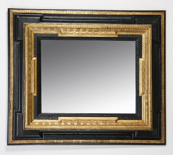 19th c. carved and gilt Dutch framed mirror: Late 19th century Dutch framed mirror, the ebonized and parcel gilt frame with staggered layers, relief carved with rippled designs, 44.5"h x 38"w.