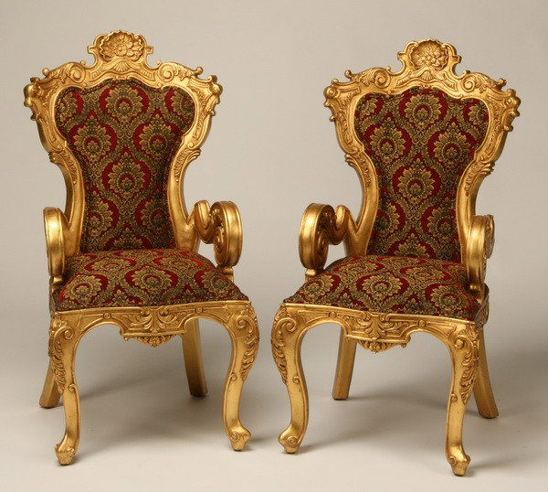 Pair of carved and gilt arm chairs: Pair of Louis XV-style carved and gilt arm chairs with scrolling arms, acanthus leaf and shell detail on the crestrail, upholstered in burgandy and gold patterned damask, 41.5"h x 21.5"w x 21"d.