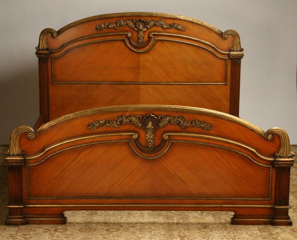NEW! Carved and parcel gilt king size bed: Carved and parcel gilt king size mahogany bed, the headboard and footboard with central relief carved shell issuing foliate swags, the footboard with carved designs on front and back; headboard 60"h x