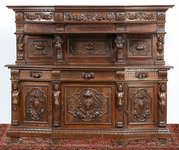 19th c. Italian carved walnut buffet: Late 19th century Italian Renaissance Revival carved walnut buffet with canted sides and upper display shelf supported by carved male mask corbels over a three drawer, three door base cabinet, the dra