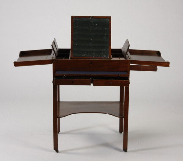 19th c. English gentleman's dressing table: Late 19th century English mahogany gentleman's dressing table that opens to reveal an adjustable mirror, hinged and lidded storage compartments, with a pull-out felt lined tray and two locking drawers