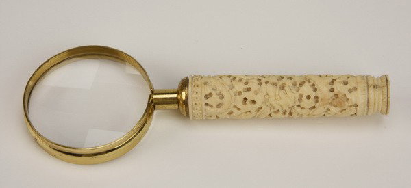 19th c. ivory handled magnifying glass: 19th century handheld magnifying glass with a round, carved ivory handle, 7.5"l x 2.5" diameter glass.