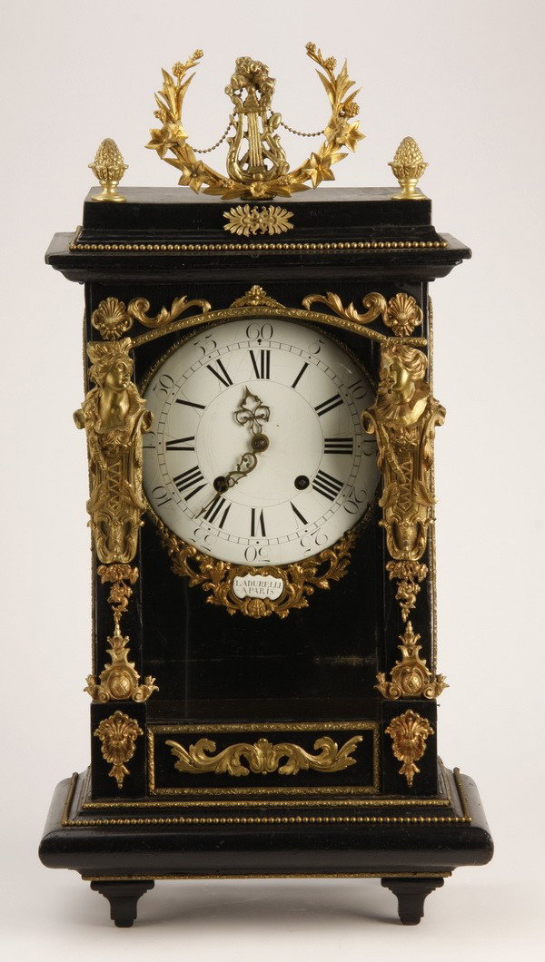 19th c. oversized French mantle clock: Early 19th century French Empire ebonized and dore' bronze mounted oversized mantle clock, the porcelain clock face surmounted by a wreath and lyre, and flanked by maiden term figures, maker marked "L