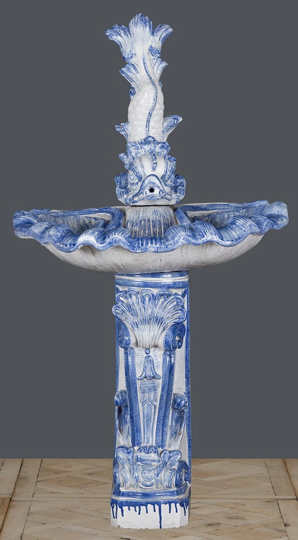 Italian majolica wall fountain: Italian majolica wall fountain in the form of a dolphin spewing water into a shell form basin, 58"h x 30"w x 23"d.