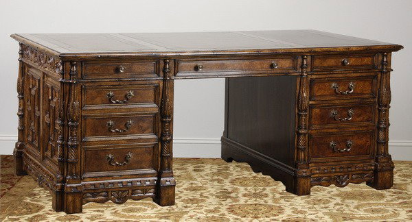New, unused executive partner's desk: New, unused, executive partner's desk in a distressed walnut finish with inset gold tooled leather top, the sides with raised and relief carved panels terminating in carved acanthus leaf pilasters, de