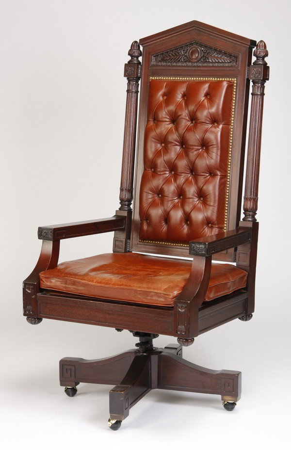 Early 20th c. carved executive armchair, 60"h: Early 20th century American high back executive swivel armchair with relief carved frame, upholstered in tufted brown leather, on brass casters, 60.5"h x 31"w x 24.5"d.