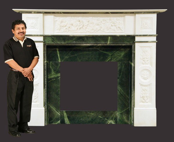 Monumental carved marble mantle, 72"h: Monumental relief carved white marble mantle, the frieze with a relief carved cherub bacchanalia scene, and a verde marble insert surrounding the firebox, 72"h x 95"w; firebox: 33"h x 36"w.