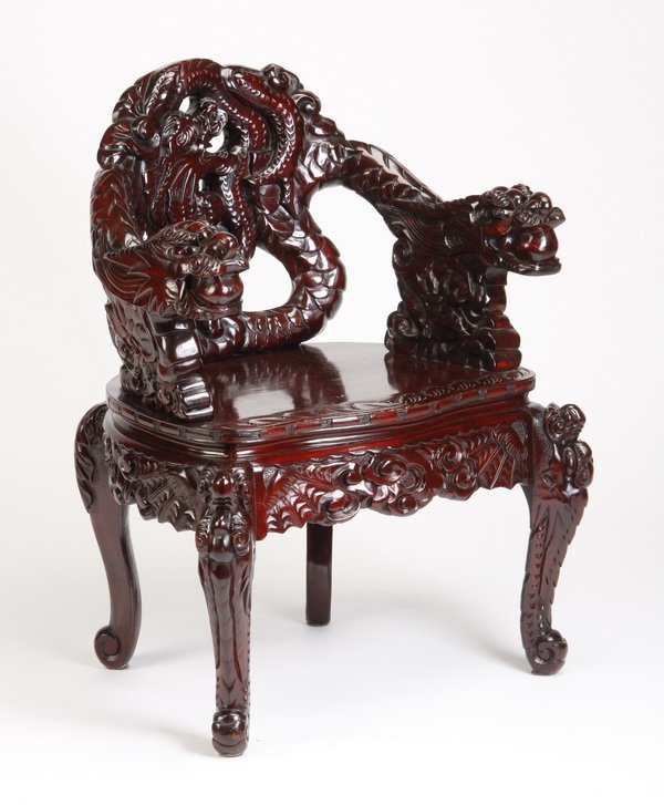 Chinese carved arm chair: 20th century Chinese carved arm chair, the back depicting a dragon in profile chasing the illusive pearl of wisdom, with dragon form arms, the solid seat over an apron with stylized clouds, 34"h x 28"