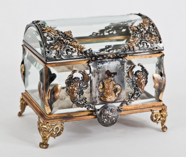 19th c. beveled glass & bronze jewelry casket: 19th century Louis XV style beveled glass locking jewelry casket with finely chased silver over bronze overlays in the form of cherubs and floral swags, 6.25"h x 7.5"l x 5"w.