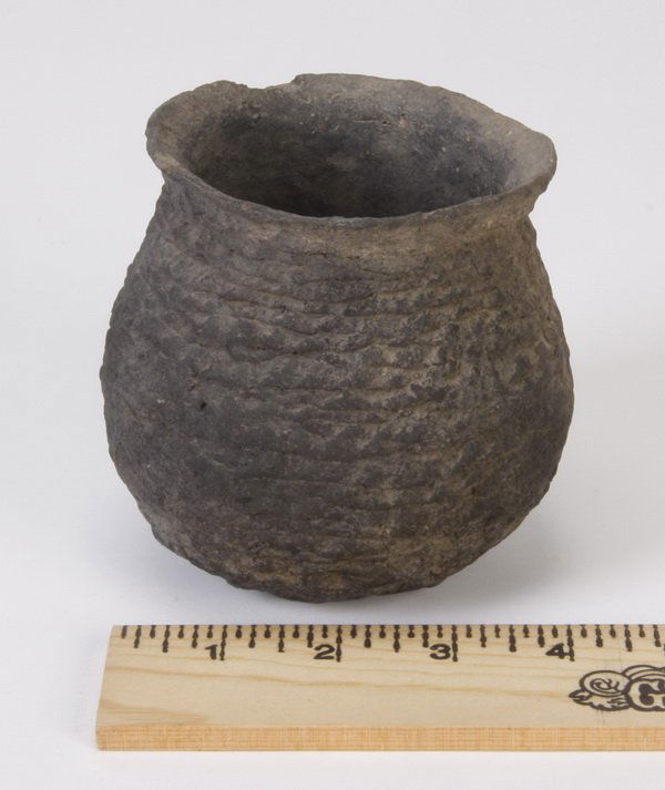 Anasazi black corrugated jar, circa 700 AD: Anasazi black corrugated pot or storage jar, circa 700-1300, made of crushed pottery and sand, of globular form with a wide opening and textured surface, 4"h x 4.5" diameter.