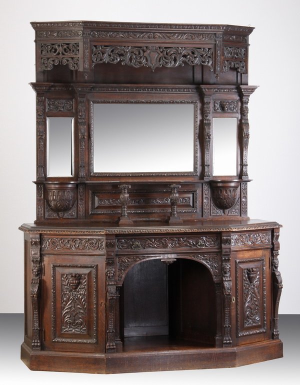 19th c. English carved oak buffet: Late 19th century English Jacobean style 2-part carved oak buffet with pierce carved cornice over a backsplash with three beveled mirrors surmounting open display shelves, the canted side base cabinet