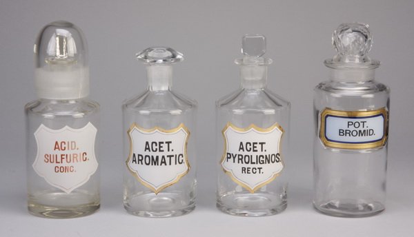 (4) Vintage clear glass apothecary bottles: Group of four vintage clear glass apothecary bottles with stoppers: (1) 8.5"h, (1) 7.5"h, (1) 8"h, (1) 8.5"h.