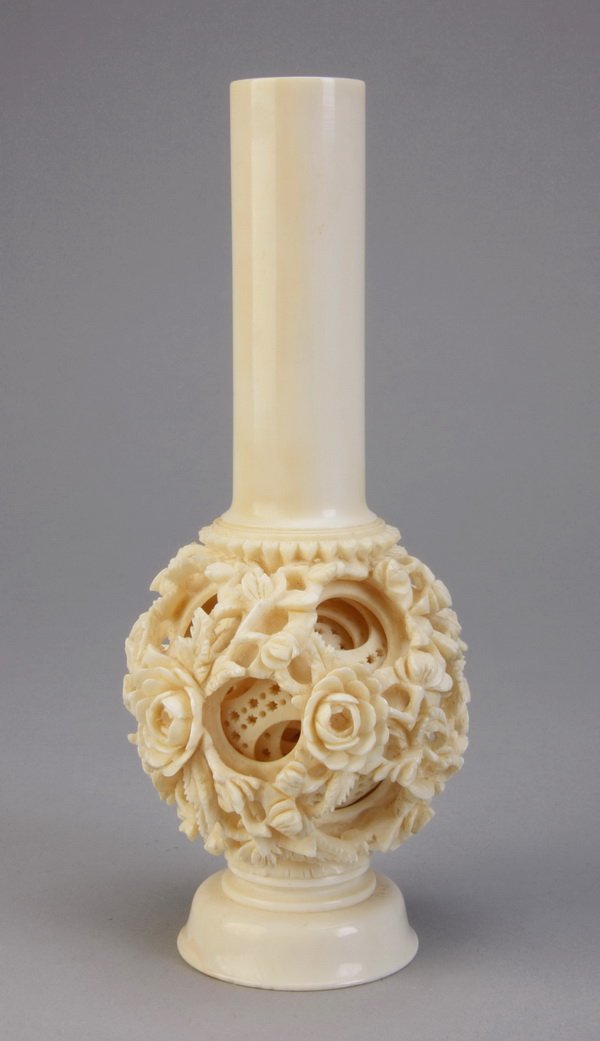 Chinese pierce carved ivory puzzle ball: 20th century Chinese pierce carved ivory footed puzzle ball, the outer sphere with fully formed foliate designs, the inner concentric balls with geometric designs, 6"h x 3" diameter.