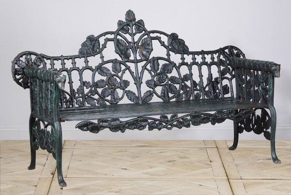 20th c. cast iron garden bench: 20th century American Gothic Revival cast iron garden bench, the backrest and arms in the form of flowing vines, each armrest terminating in a hound's head, 42"h x 72"l x 25"d.