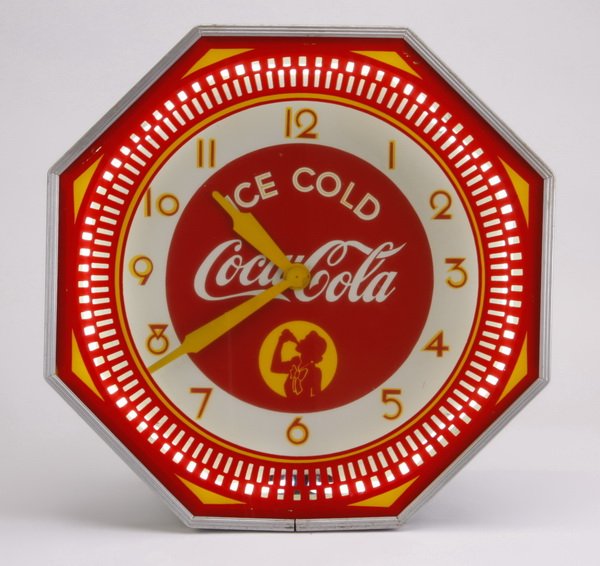 Mid 20th c. Coca Cola wall clock: Mid 20th century octagonal Coca-Cola electric advertising clock, the red and yellow face with Art Deco style numbers illuminated by a neon bulb, 18.5" diameter x 7"d.