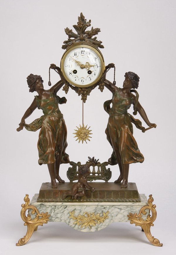 19th c. French figural clock: Late 19th century French polychrome metal and marble figural clock, the fruit and foliate adorned case with stylized sun pendulum supported by a pair of standing maidens, all over a marble base raised