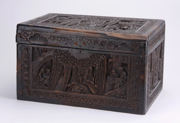 Chinese hand carved camphor wood box: Late 19th or early 20th century Chinese hand carved camphor wood chest with hinged lid, each façade relief carved with a central foliate design flanked by figures and architectural details, all withi