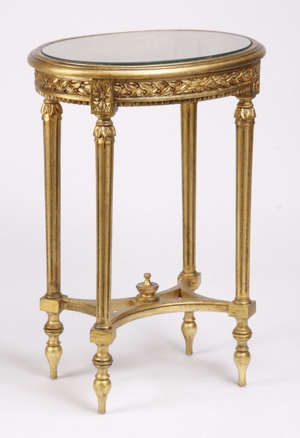 Louis XVI style gilt wood table vitrine: Early 20th century Louis XVI style oval gilt wood accent table, with display area beneath the glass top, all raised on fluted tapering legs joined by an X-shaped stretcher, 28.5"h x 19.5"w x 15.5"d.