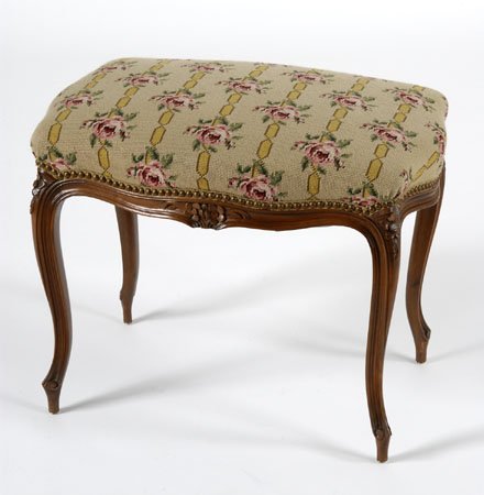 French Provincial needlepoint stool: Walnut French Provincial stool in needlepoint upholstery with a ribbons and roses design, 18.5"h x 25"l x 17.5"w.