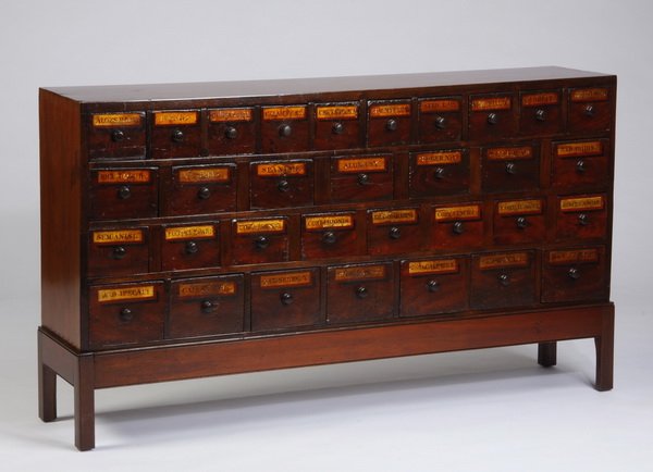 20th c. apothecary chest on stand: 20th century mahogany and pine apothecary chest on stand with hand painted labels on the drawer fronts, 30"h x 60"l x 12.5"d.