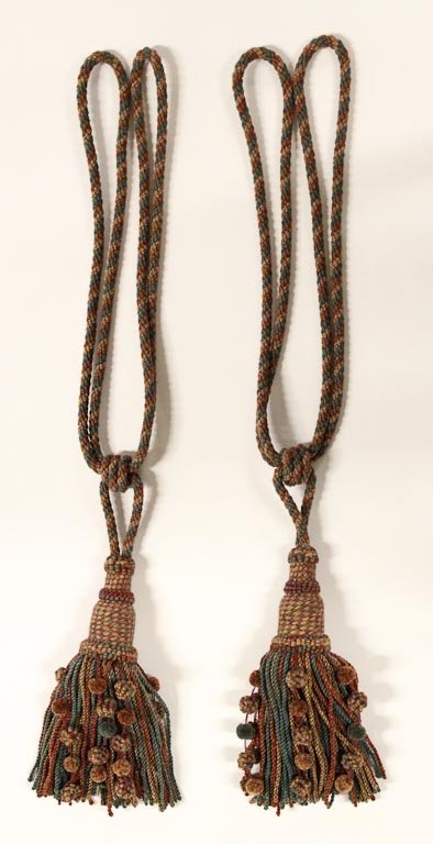 (2) Custom designed tie-backs or tassels: Pair of extravagant, custom designed and fabricated tie-backs or tassels in shades of red, gold, and green, each 32"l x 7"w.