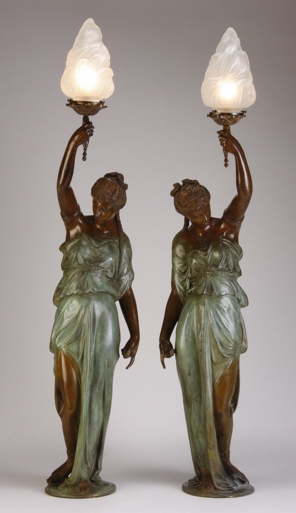 (2) 20th c. bronze figural torcheres: Pair of 20th century patinated bronze figural torcheres, the opposing Neoclassical style female figures holding a torch aloft with flame shaped frosted glass shade, after Mathurin Moreau, 49"h x 11"w 