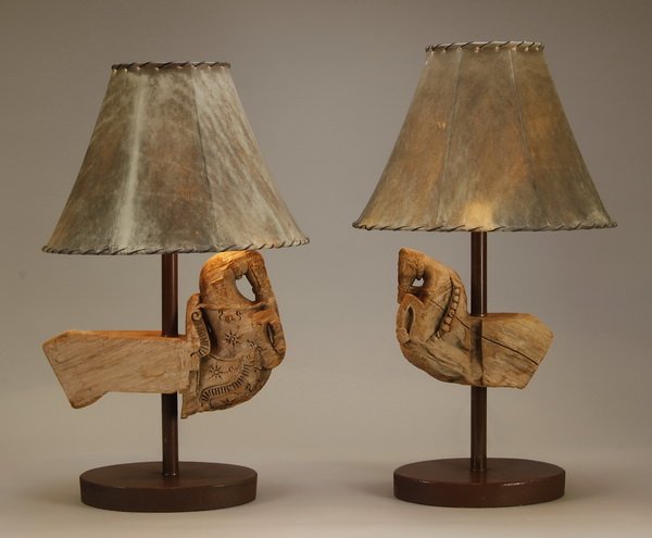 (2) Carved wood table lamps, hide shades: Pair of figural table lamps with hide shades, the brown metal stems with carved wood partially formed horses, on oval bases, 28"h x 16"w x 15"d.