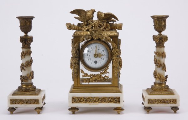 19th c. alabaster and bronze garniture set: Late 19th century gilt bronze mounted alabaster petite garniture set consisting of a bracket clock and pair of candlesticks, the clock with a pair of fully formed lovebirds among flowers surmounting a