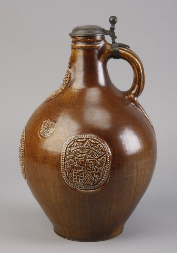 Vintage German-Austrian wine jug: Late 19th or early 20th century German-Austrian wine jug with pewter cover and embossed royal shields, hallmarked illegibly on the bottom, 14"h x 10" diameter at the center.