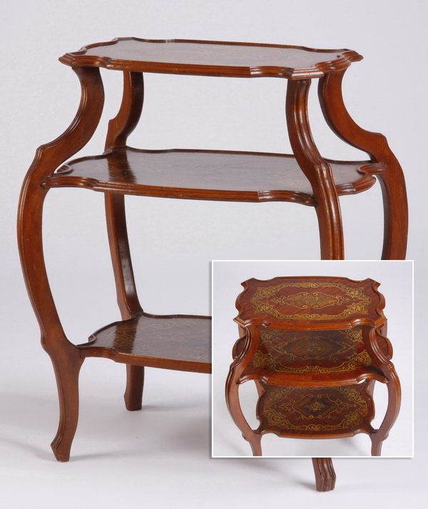 Marquetry inlaid three-tier table: Mid 20th century three-tier display table, the shaped shelves with marquetry inlaid floriate and foliate scrollwork against a book matched veneer ground, all raised on channeled serpentine legs, 34"h