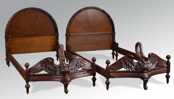 (2) Swan form mahogany twin beds: Pair of early to mid 20th century American carved and marquetry inlaid mahogany twin beds, in the style of Berkey & Gay, the arched headboards with a central Art Deco starburst terminating in stylized