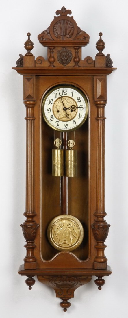 19th c. 2-weight Vienna regulator clock: 19th century carved walnut two weight Vienna regulator clock with stylized shell carved pediment surmounting a lion's mask, the enameled clock face with dore' bronze center and matching pendulum, 47"h