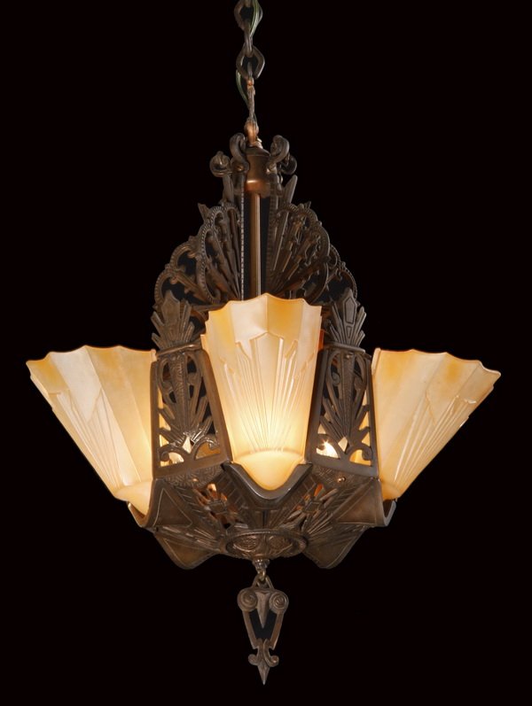 Early 20th c. Art Deco chandelier: Early 20th century Art Deco cast iron 5-light chandelier, circa 1930, the circular corona surmounting a piercework frame with scrolling designs, fitted with slip glass shades in an alabaster color, ap