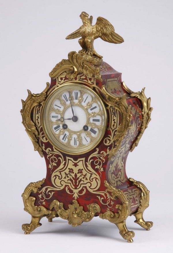 Late 19th c. Boulle-style gilt bronze clock: Late 19th century Louis XIV style gilt bronze mounted mantel clock, with brass and tortoiseshell inlay in the manner of André-Charles Boulle, the shaped case surmounted by an eagle and trimmed with a