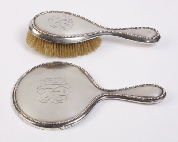 (2) Pc. sterling silver vanity set: Early 20th century American sterling silver 2-piece vanity set with a beaded border and engraved monogram EKB, maker marked Simpson, Hall, Miller & Co., includes (1) hand held beveled glass mirror, 10