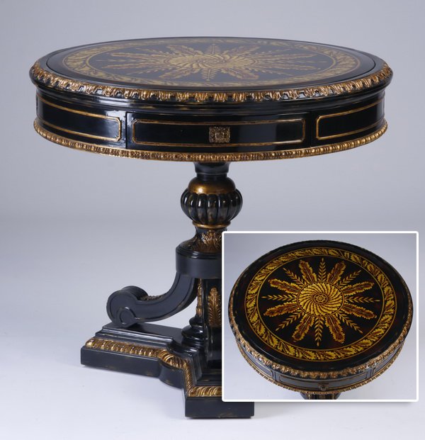 Maitland-Smith parcel gilt table: Contemporary carved and parcel gilt ebonized wood occasional table, the round top with hand worked foliate designs and inset beveled glass, over an apron with a single drawer, all raised on three acan