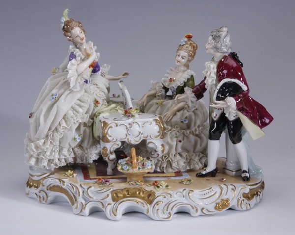 20th c. German porcelain figural grouping: Mid to late 20th century German porcelain figural grouping, depicting three people in period dress encircling a piano, maker marked Unter Weiss Bach, (losses to the back of one figure),10"h x 13"w x 9