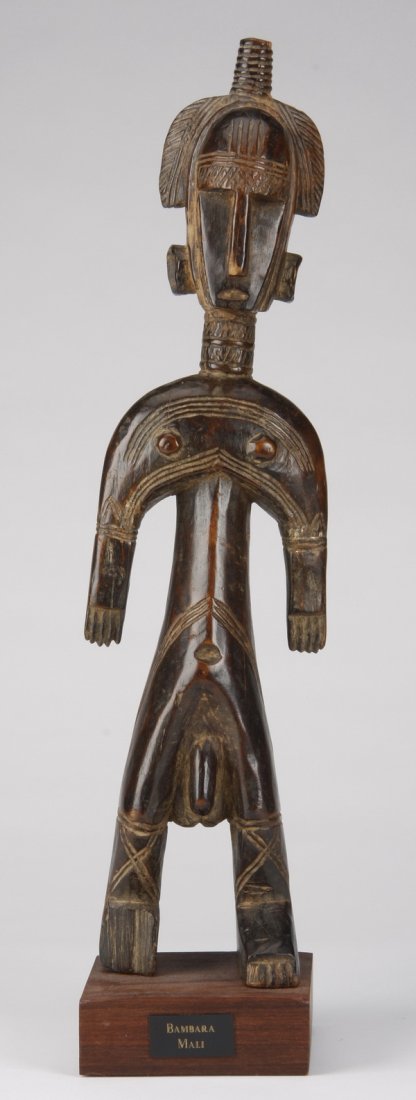 Bambara male figure, Mali: Bambara male figure, Mali, used during initiation rituals, the carved wood form posed at a slight angle, with an elaborate coiffure and incised geometric details, 16.5"h x 5"w, overall size with stand