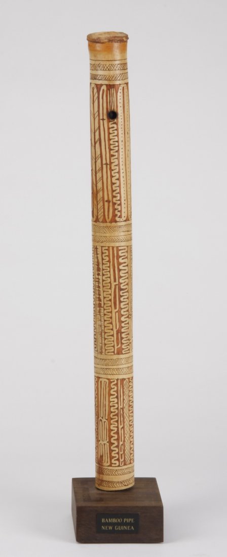 Bamboo stalk pipe, Papua New Guinea: Mid 20th century bamboo stalk pipe, Papua New Guinea, of cylindrical form with painted geometric decoration, 17"l x 1"w, overall size with stand 18.5"h x 3.25"w x 5.75"d.