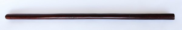 40"l Fijian pole club: Fijian pole club or "gadi", the cylindrical wood form carved with zigzags separated by vertical lines, a motif known as "tavatava", 40"l x 1.5"w.