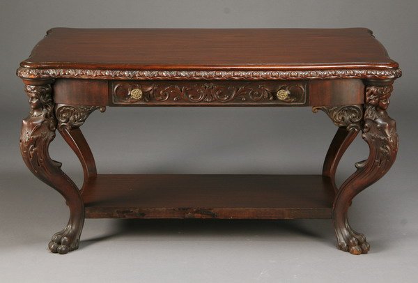 19th c. American mahogany center table: Late 19th century American mahogany center table with relief carved center frieze drawer on both sides, supported by four standing maiden figures terminating in lion's paw feet and joined by a slab fo