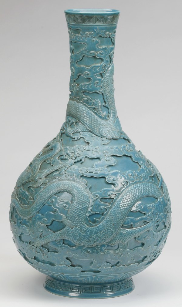 19th c. Chinese porcelain bottle vase, marked: Late 19th century Chinese turquoise porcelain bottle vase, carved with dragons chasing flaming pearls amidst scrolling clouds, the base with a Qianlong mark, 21.5"h x 13"w.