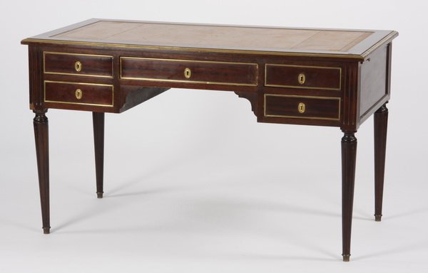French bronze mounted mahogany desk: Late 19th or early 20th century French bronze mounted mahogany desk, the rectangular top with an inset tooled gilt leather writing surface, above four side drawers and one central drawer, with a pull-